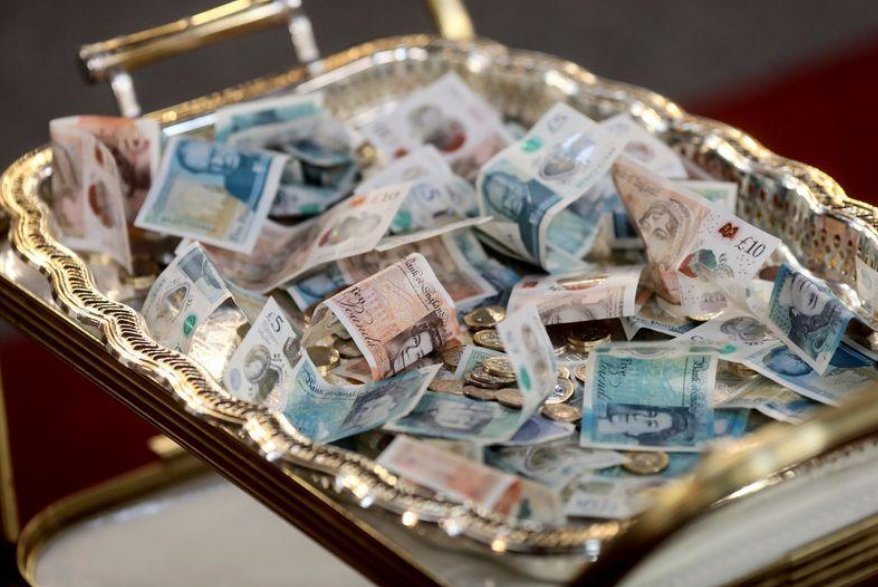 Sterling notes sit on a collection tray during a Good Friday Lent church service at the Eternal Sacred Order of Cherubim & Seraphim Church in London, Britain, March 30, 2018. REUTERS/Simon Dawson