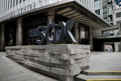 FILE PHOTO: A man wearing a protective face mask walks past the Singapore Exchange (SGX) in central business district area in Singapore, April 7, 2020. REUTERS/Edgar Su