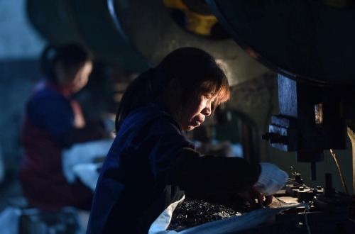 FILE PHOTO: Employees work on a production line manufacturing metal parts for furniture at a factory in Hangzhou, Zhejiang province, China April 30, 2020. China Daily via REUTERS