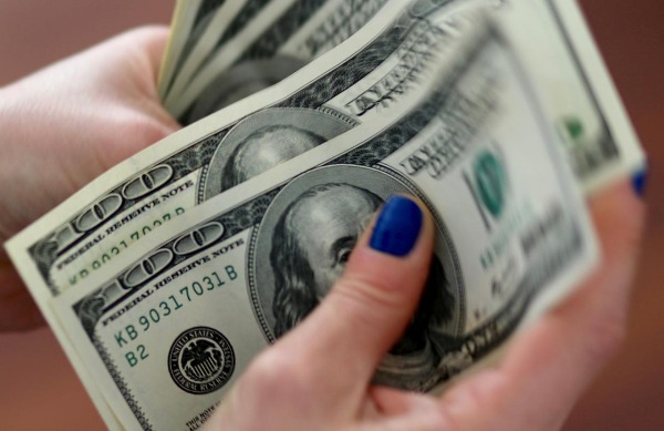 FILE PHOTO: A woman counts U.S. dollar bills at her home in Buenos Aires, Argentina August 28, 2018. REUTERS/Marcos Brindicci