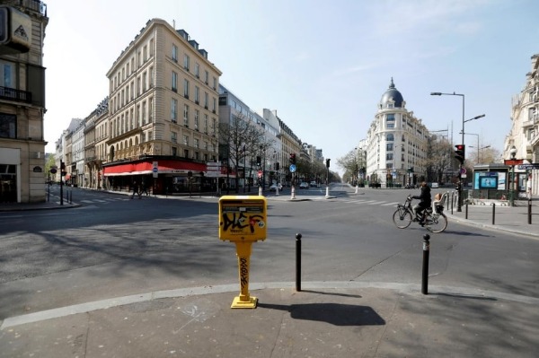 A cyclist rides on the deserted Grands Boulevards in Paris as a lockdown is imposed to slow the rate of the coronavirus disease