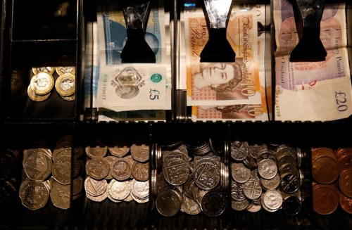 FILE PHOTO: Pound Sterling notes and change are seen inside a cash resgister in a coffee shop in Manchester, Britain, Septem,ber 21, 2018. REUTERS/Phil Noble